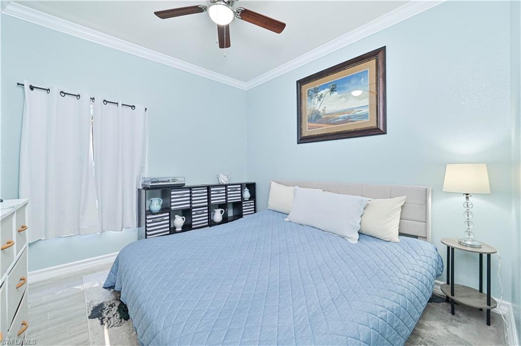 Bedroom with ornamental molding and a ceiling fan