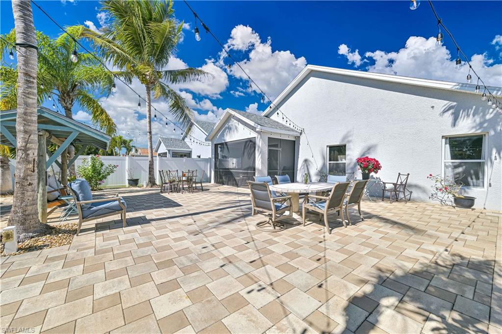 View of patio featuring outdoor dining area and a sunroom