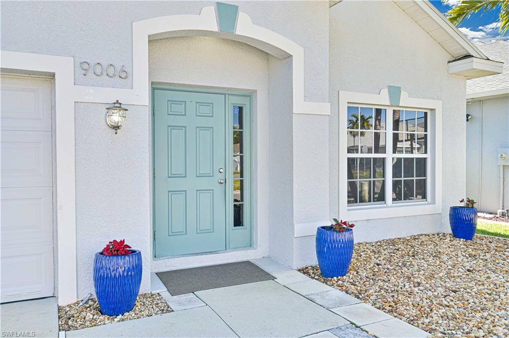 Property entrance with a garage and stucco siding