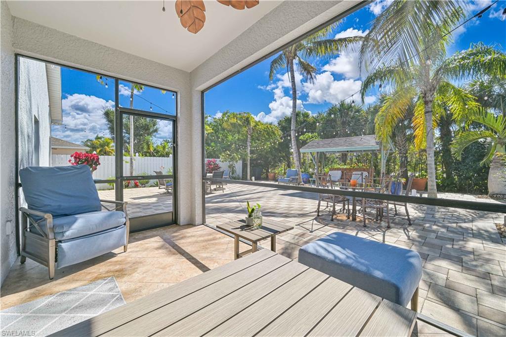Sunroom with outdoor dining area, a ceiling fan, and a patio