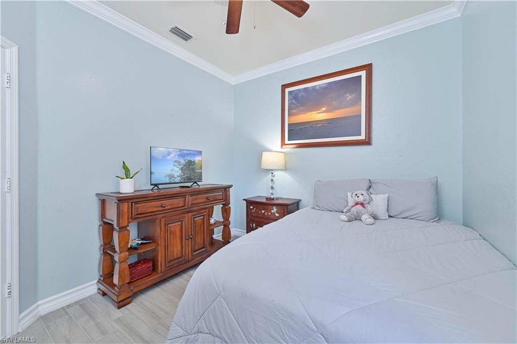 Bedroom featuring ornamental molding, ceiling fan, and light wood-type flooring