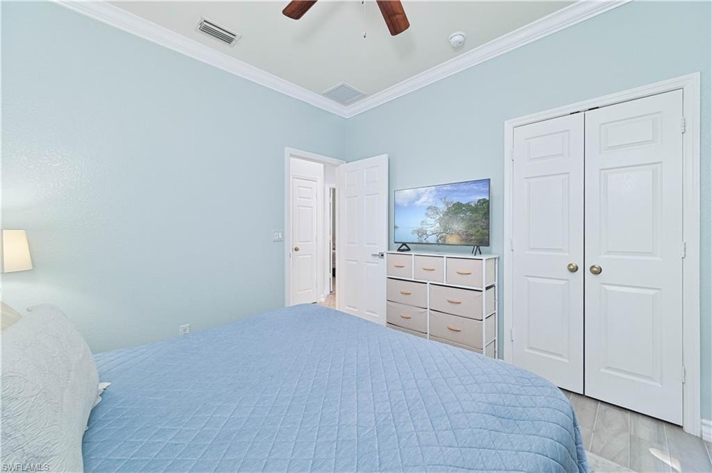 Bedroom featuring crown molding, a closet, a ceiling fan, and wood finished floors