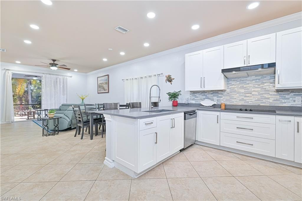 Kitchen featuring crown molding, recessed lighting, white cabinetry, a peninsula, and tasteful backsplash