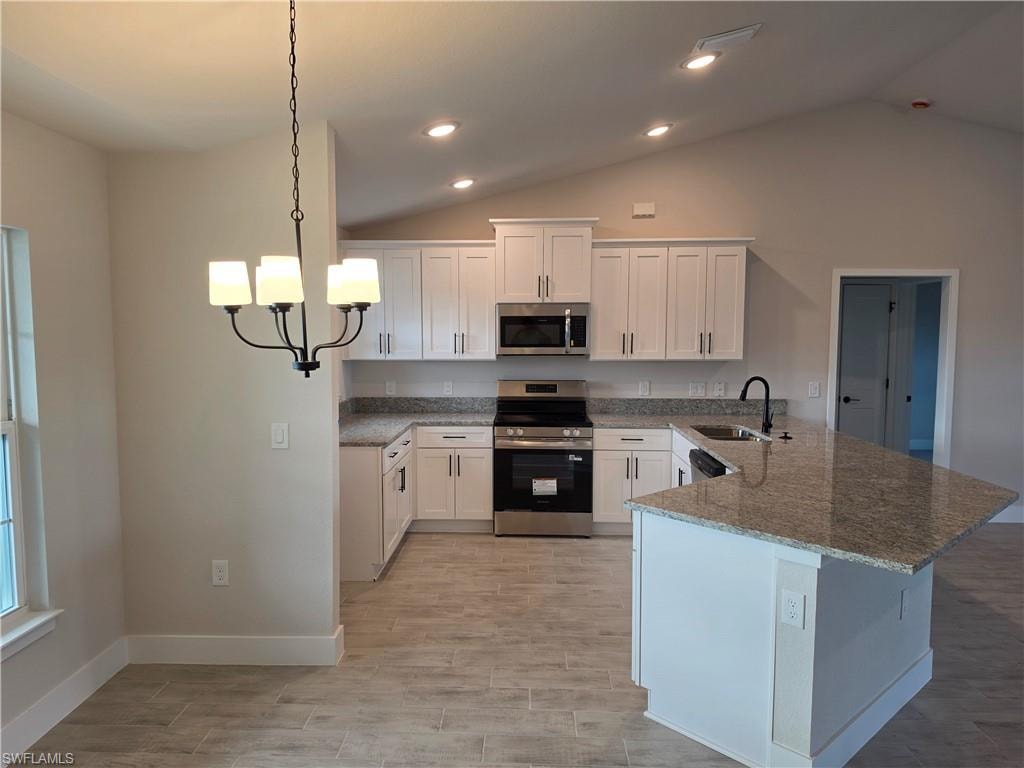 Open-concept kitchen featuring white shaker cabinetry, granite countertops, stainless steel appliances, and a central island with an undermount sink