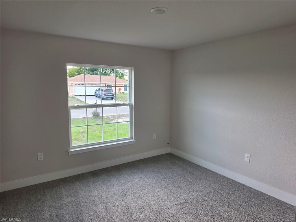 Carpeted room featuring a single window, white baseboards, and a recessed ceiling light