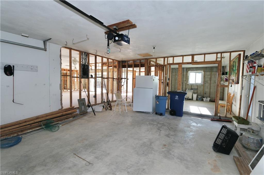 Garage with freestanding refrigerator and a garage door opener
