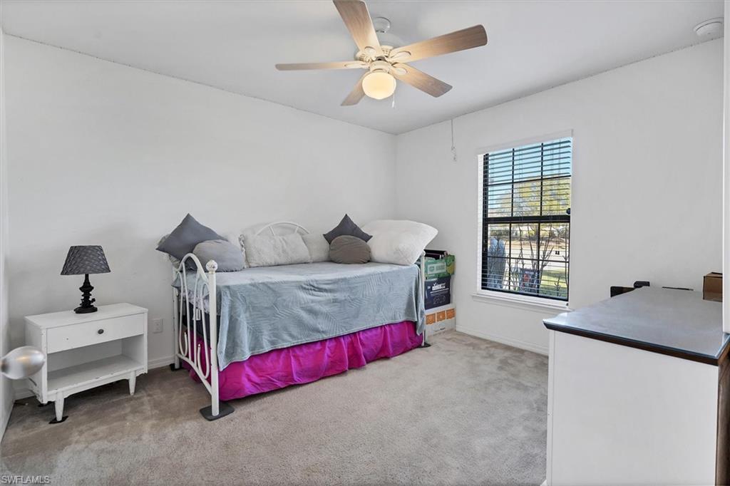 Bedroom featuring light carpet and a ceiling fan