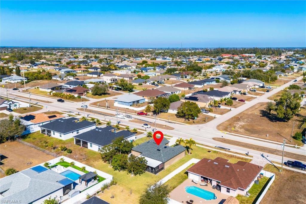 Aerial view of property and surrounding area with nearby suburban area