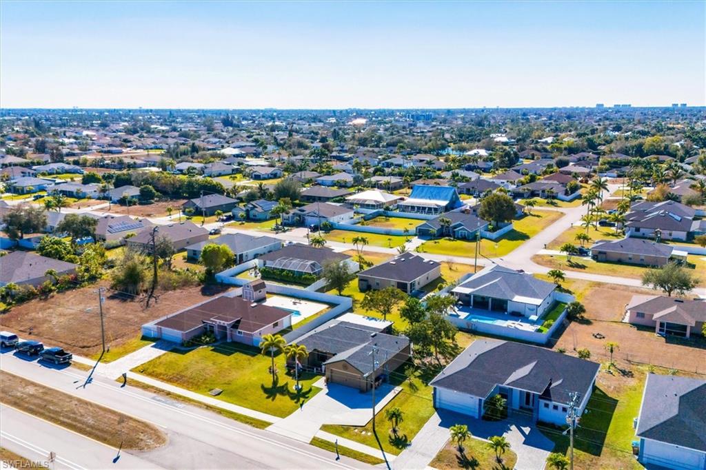 Aerial view of property and surrounding area with nearby suburban area