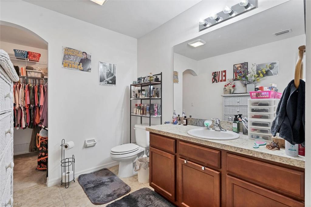 Bathroom with vanity, a spacious closet, and light tile patterned flooring