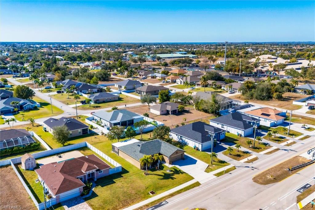 Aerial view of property and surrounding area with nearby suburban area
