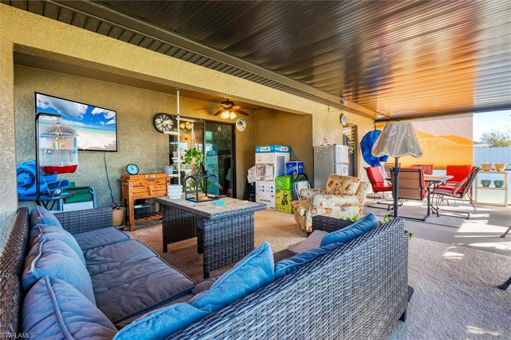 View of patio with an outdoor living / dining area and a ceiling fan
