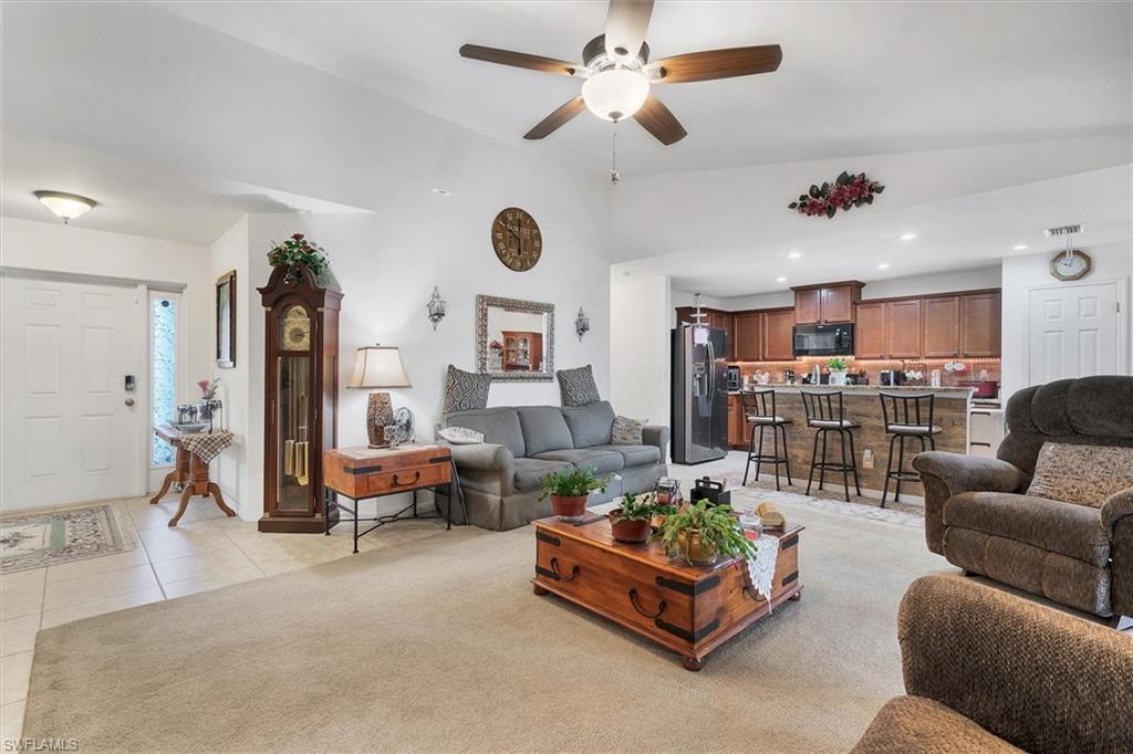 Living area featuring vaulted ceiling, ceiling fan, recessed lighting, and light tile patterned flooring