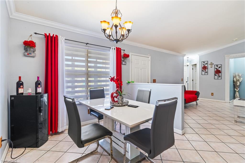 Living area featuring crown molding, a ceiling fan, and light tile patterned floors