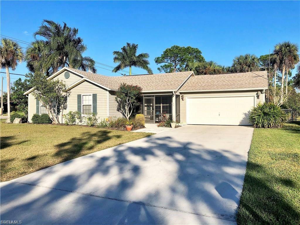 Ranch-style house with an attached garage, a front yard, driveway, and a sunroom