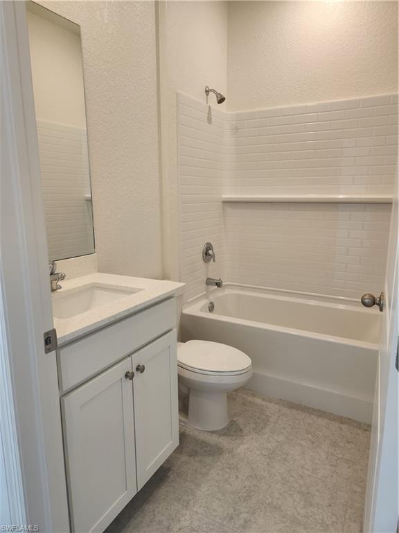 Bathroom with a textured wall, vanity, and shower / tub combination