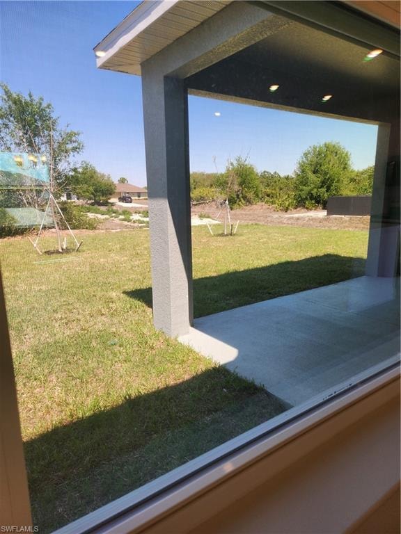 View of green lawn with a patio area