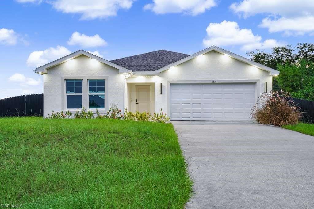 Ranch-style home with stucco siding, a garage, concrete driveway, and roof with shingles