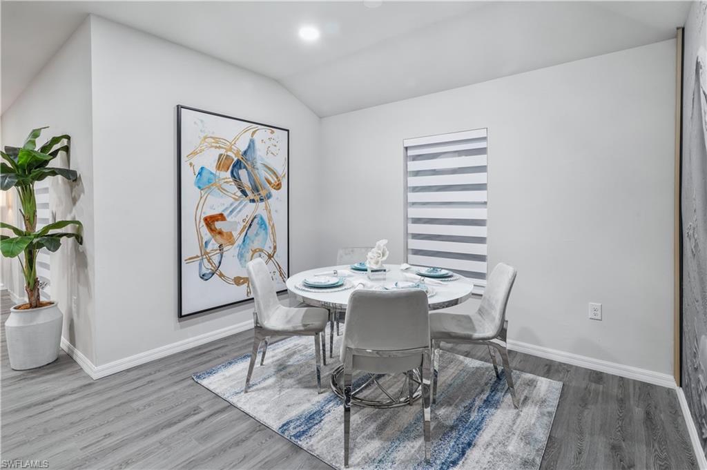 Dining space featuring vaulted ceiling and wood finished floors