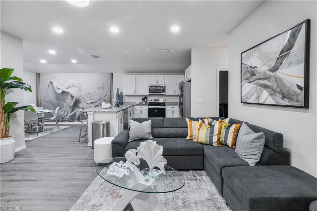 Living room with light wood finished floors and recessed lighting