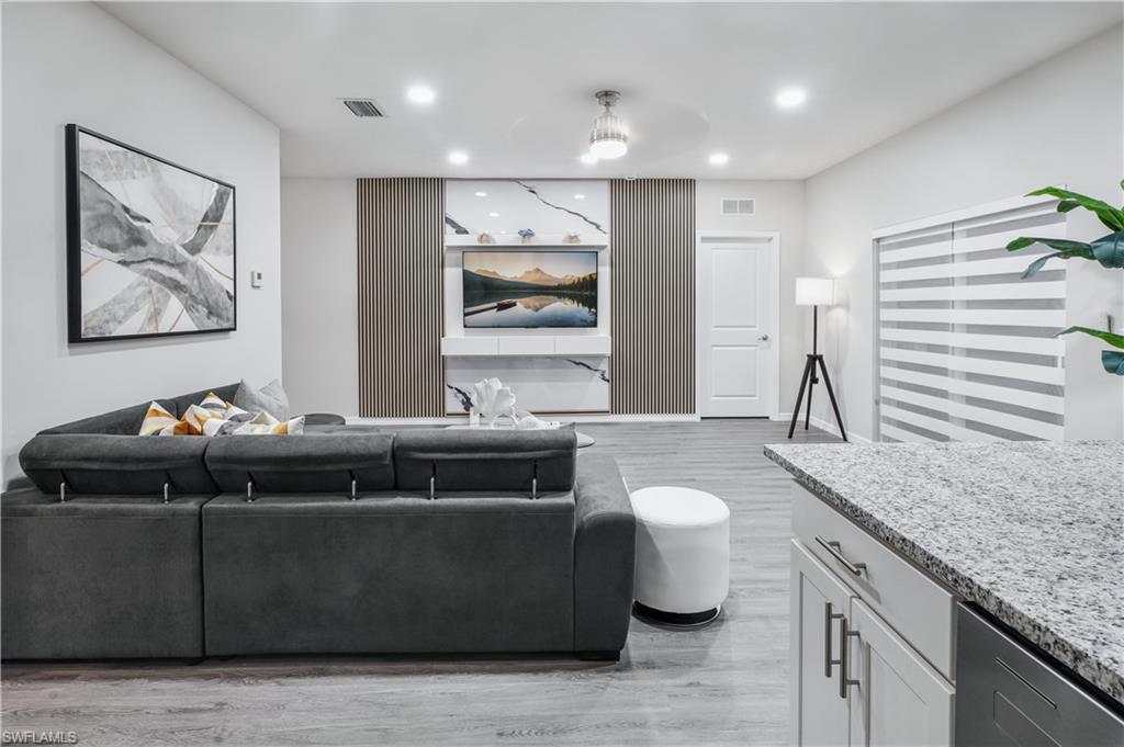 Living room with light wood finished floors and recessed lighting