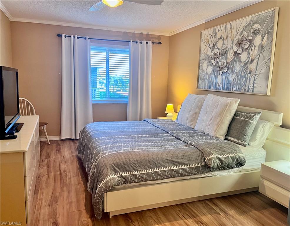 King size bed with natural light, TV and sitting area and vinyl plank flooring