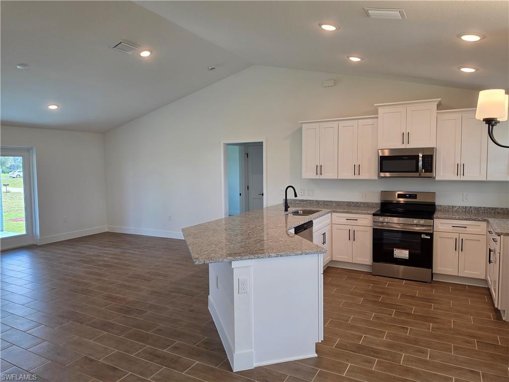 Kitchen featuring white shaker cabinetry, stainless steel appliances, and light-toned countertops