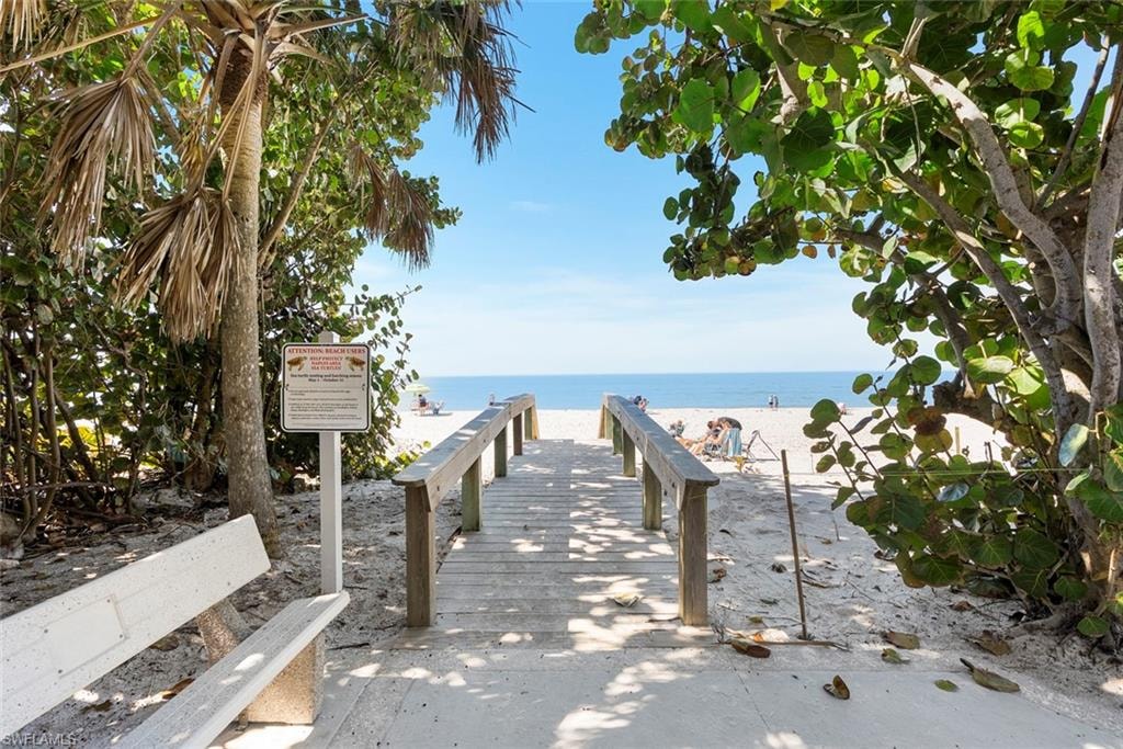Surrounding community featuring view of water and beach