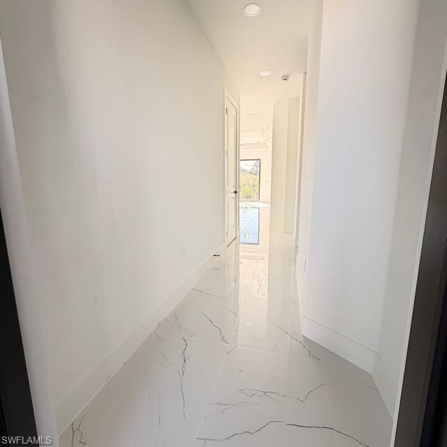 Hallway with light marble finish flooring and recessed lighting