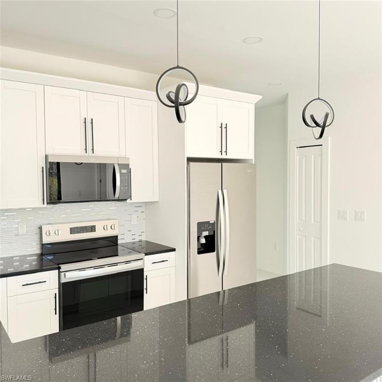 Kitchen with stainless steel appliances and white cabinetry