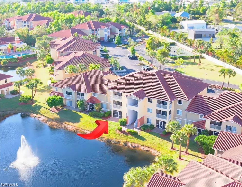 Waterfront condominium building with multiple balconies and tile roofs