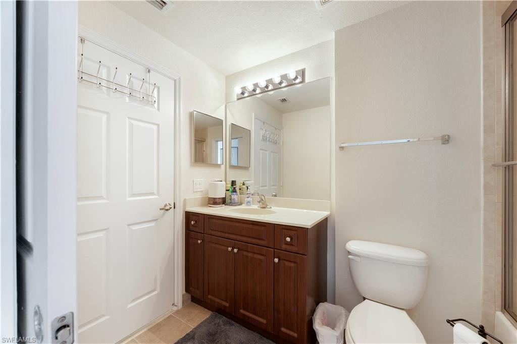 Bathroom featuring vanity, light tile patterned floors, and an enclosed shower