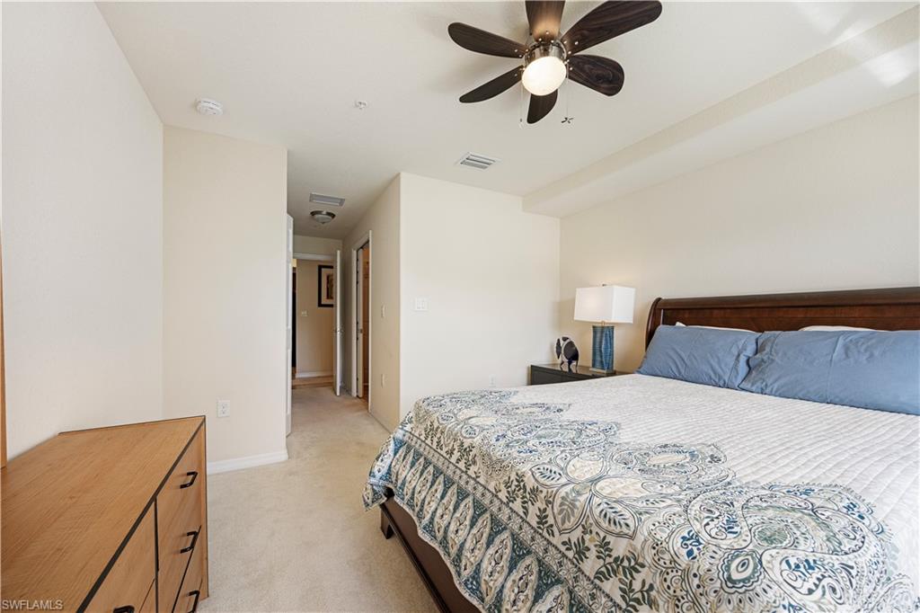 Bedroom with light carpet and a ceiling fan