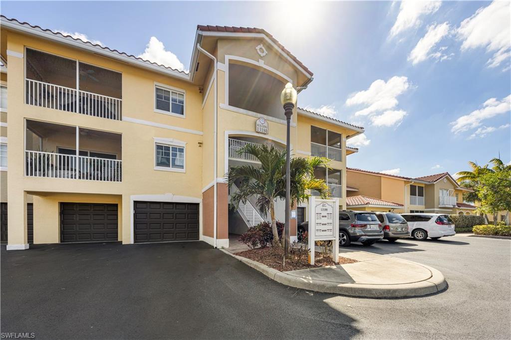 View of apartment building / complex featuring a garage and driveway
