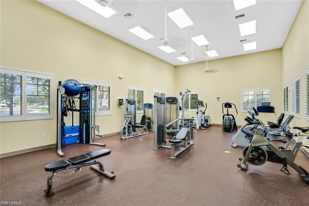 Exercise room with a high ceiling and a ceiling fan