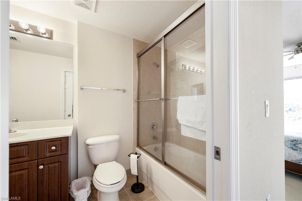 Bathroom featuring enclosed tub / shower combo, a ceiling fan, vanity, connected bathroom, and tile patterned floors