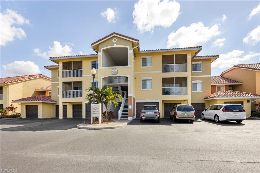 View of apartment building / complex with a garage and driveway