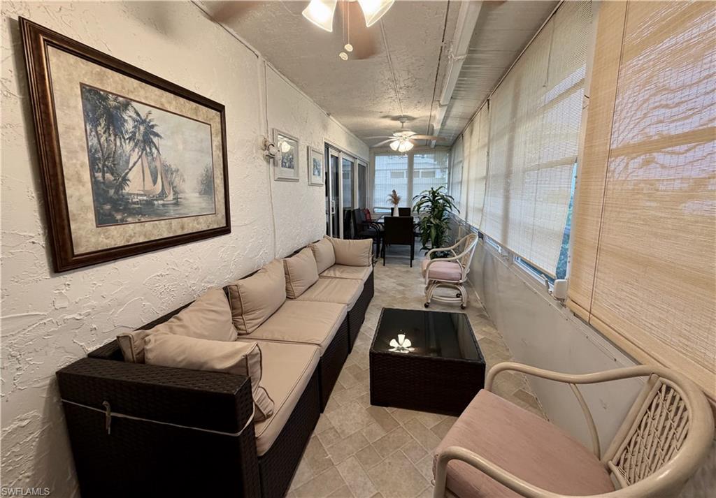 Enclosed lanai area with space to lounge and eat overlooking the golf course and water feature.