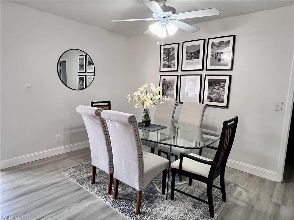 Dining space with a textured ceiling, a ceiling fan with luxury plank flooring.