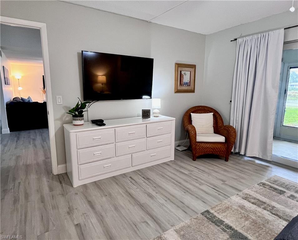 Master bedroom television with chair for reading and access to the lanai