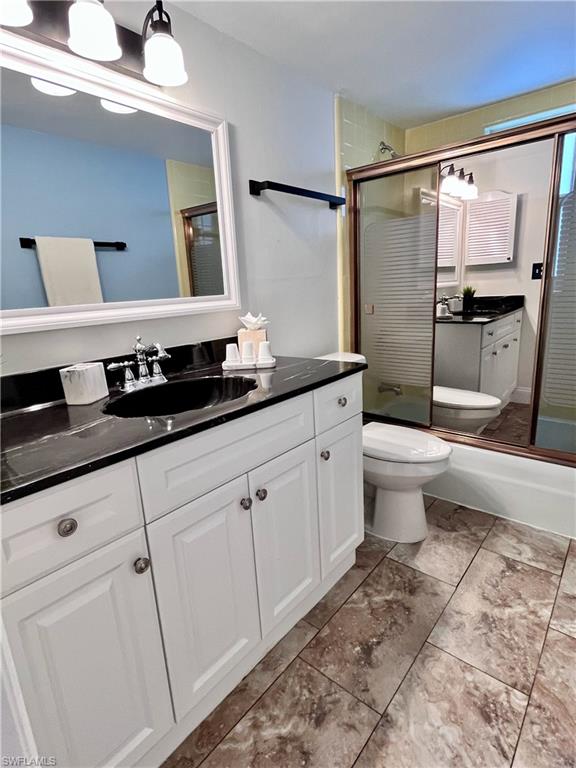 Bathroom featuring single sink vanity, tub and shower doors