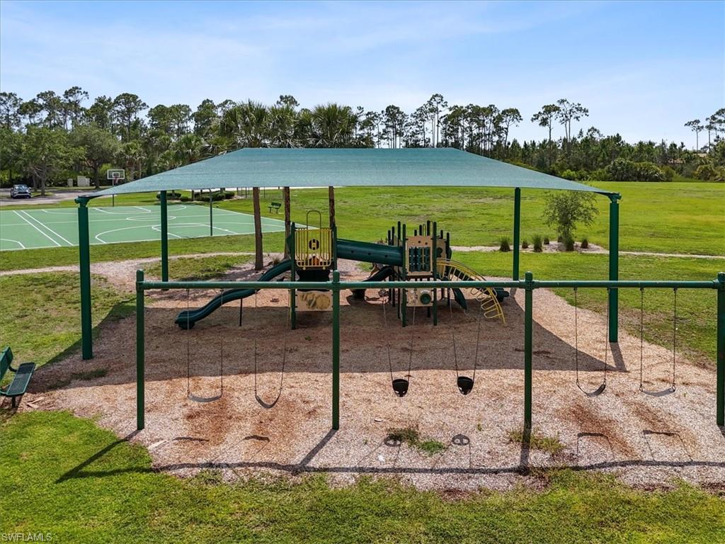 Community playground featuring a lawn and community basketball court
