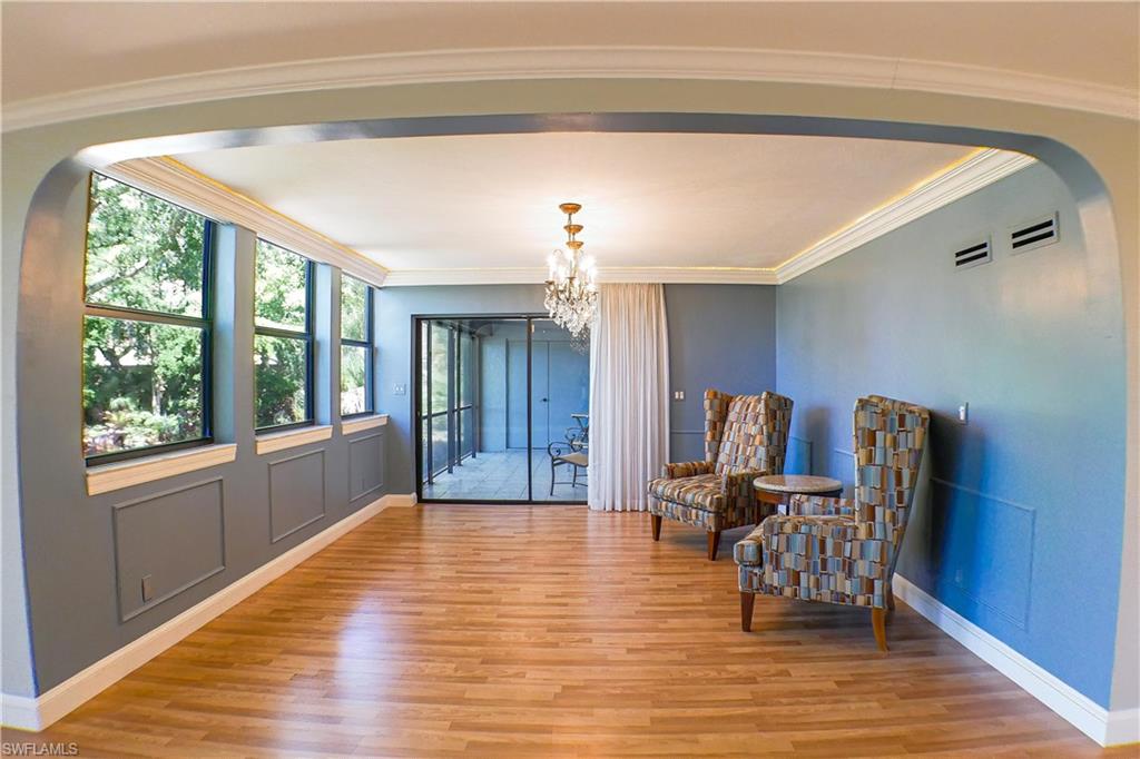 Unfurnished room with a ceiling fan, crown molding, light wood finished floors, and expansive windows