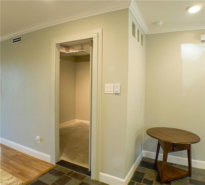 Hall featuring crown molding and dark wood-type flooring