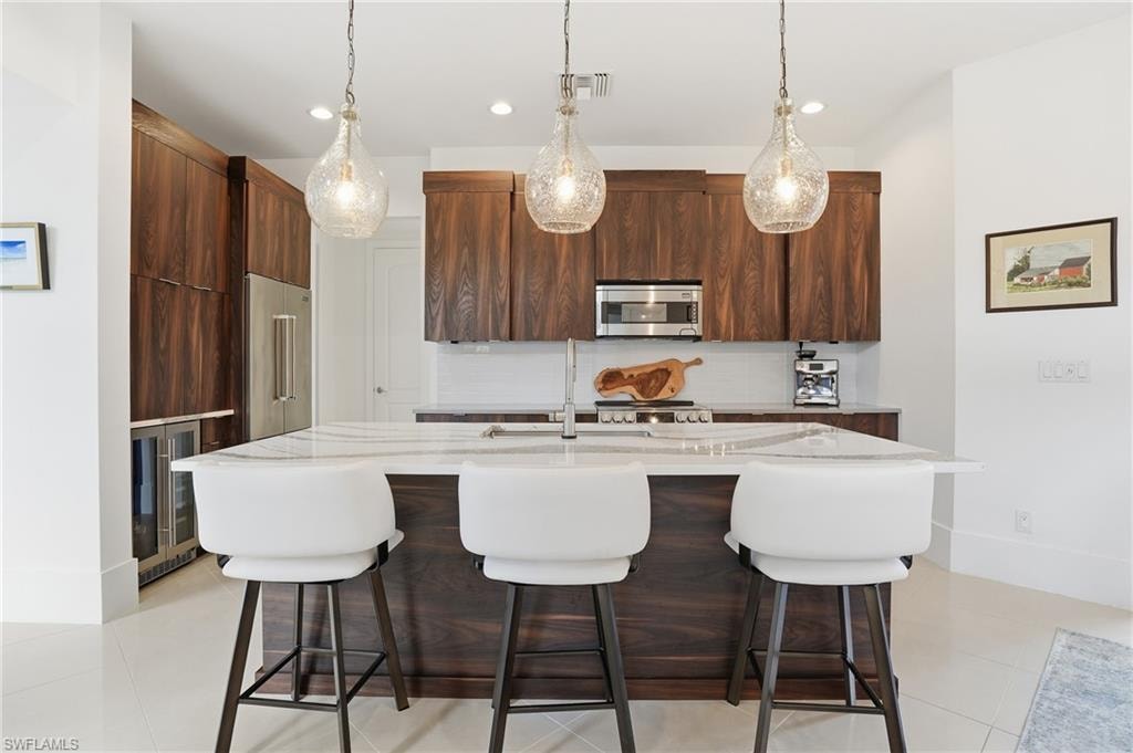 Kitchen featuring a breakfast bar area, modern cabinets, and light stone countertops