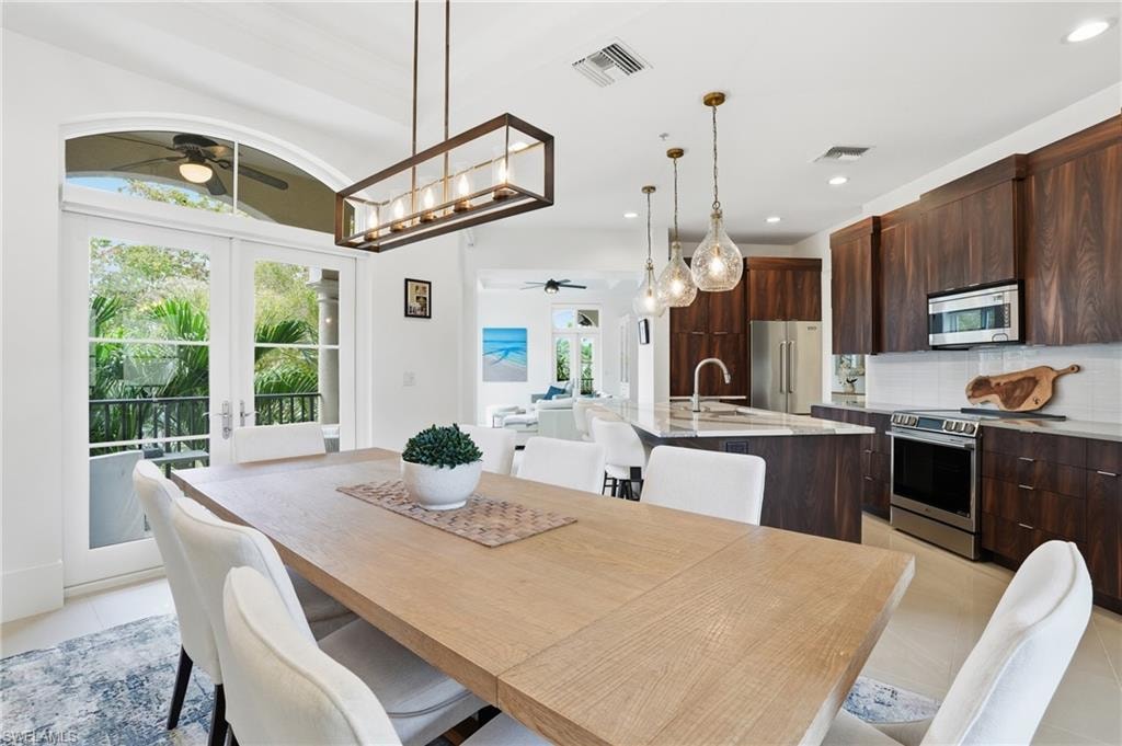 Dining room with ceiling fan, french doors, light tile patterned flooring, and recessed lighting