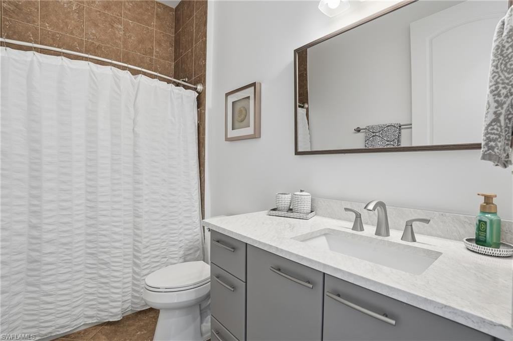 Bathroom with a shower with curtain and vanity