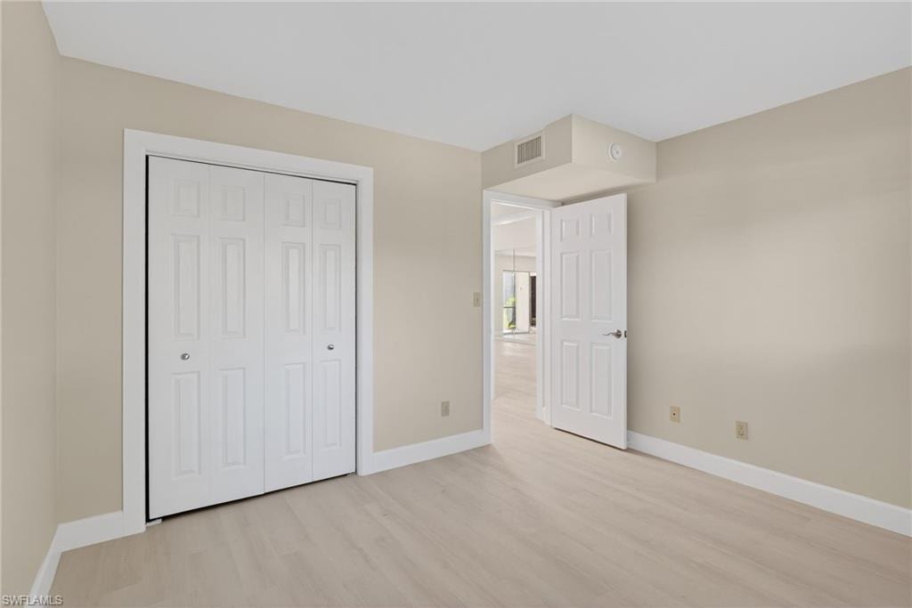 Unfurnished bedroom featuring light vinyl-style floors and a closet