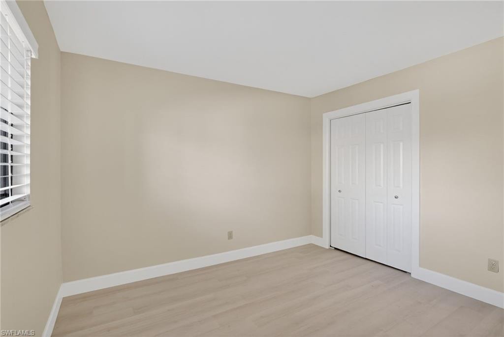 Unfurnished bedroom featuring light vinyl-type flooring and a closet