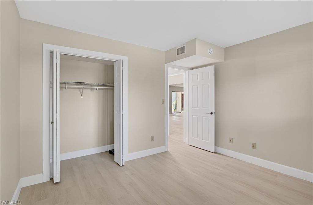 Unfurnished bedroom featuring light vinyl-style floors and a closet